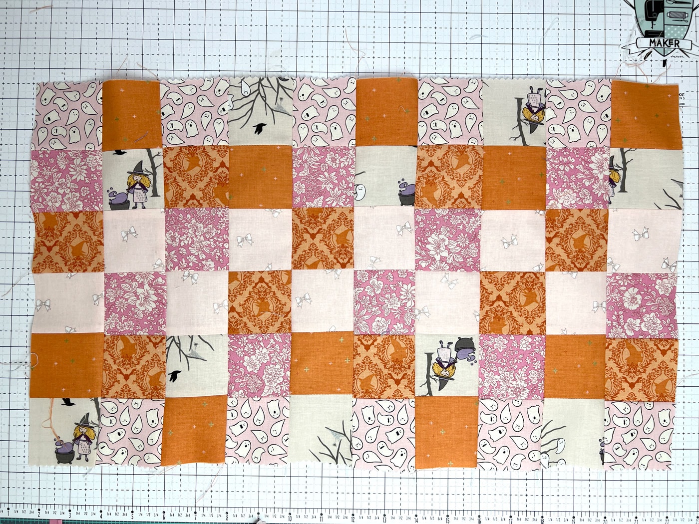 orange, pink and ivory strips of fabric being cut with rotary cutter and ruler