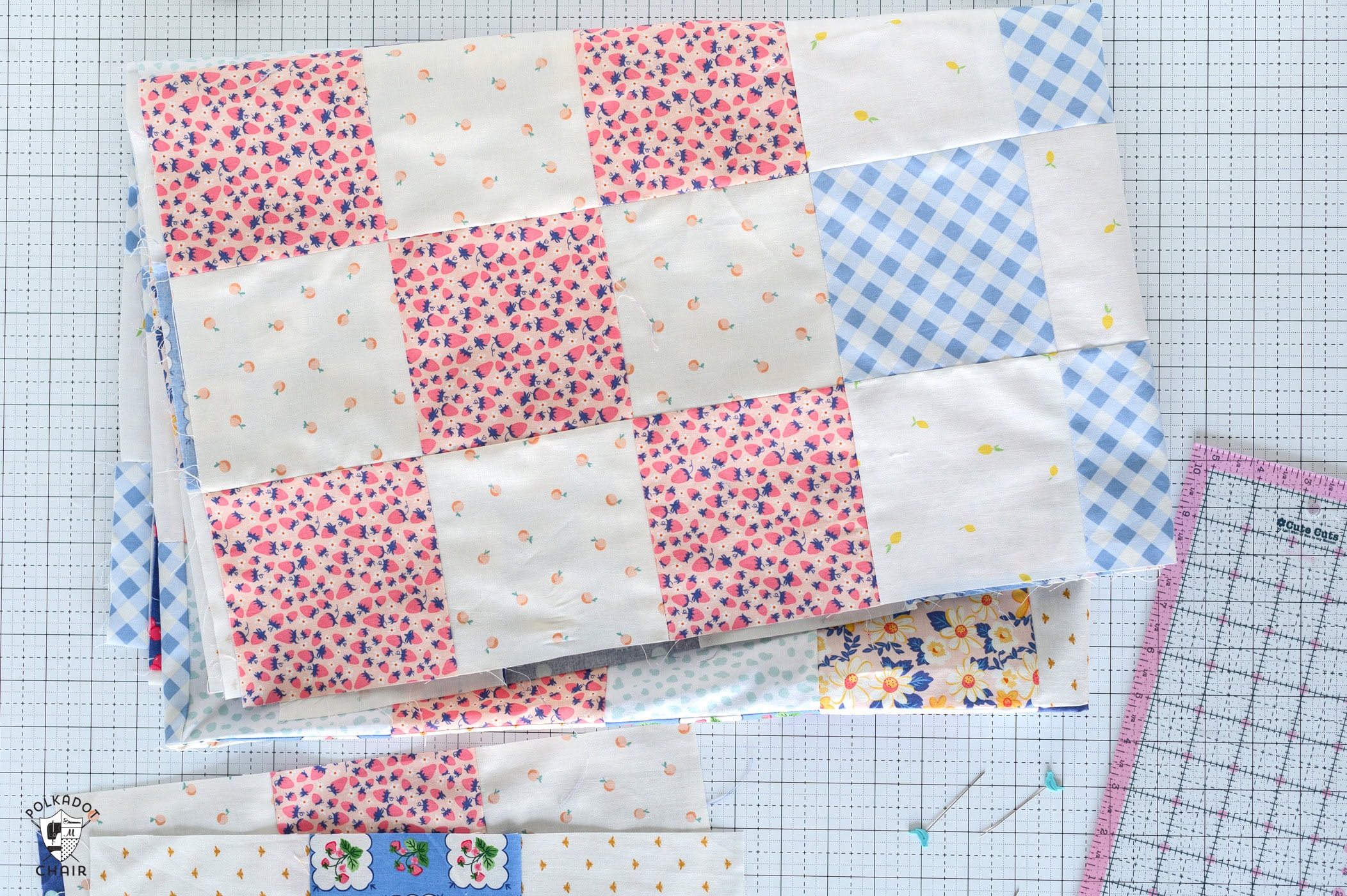 various pieces of fabric and quilting notions on white cutting mat