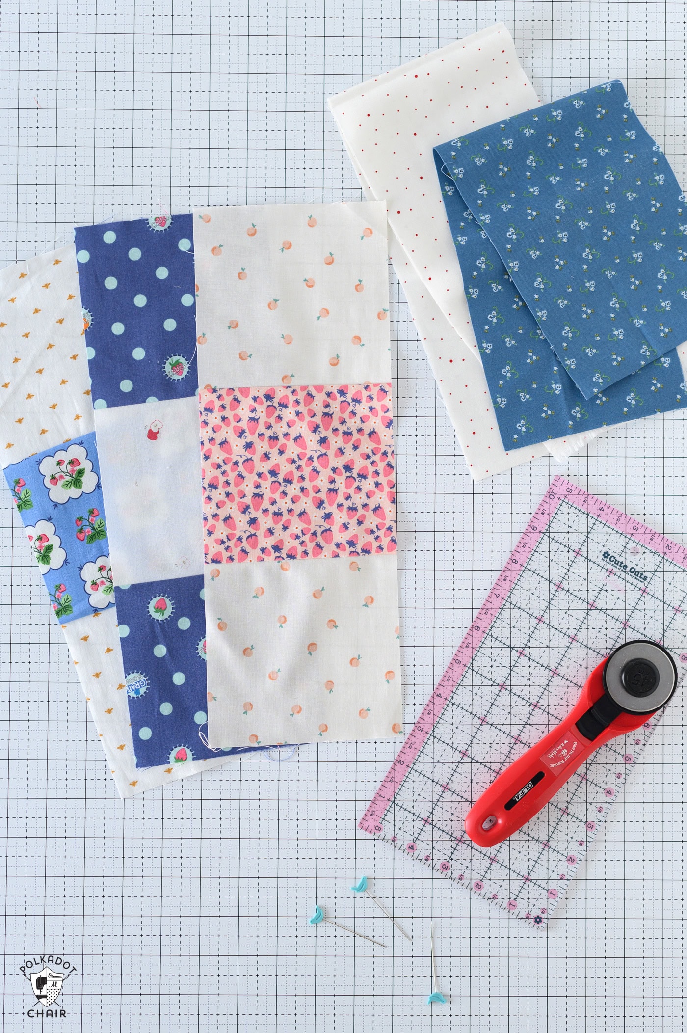 various pieces of fabric and quilting notions on white cutting mat