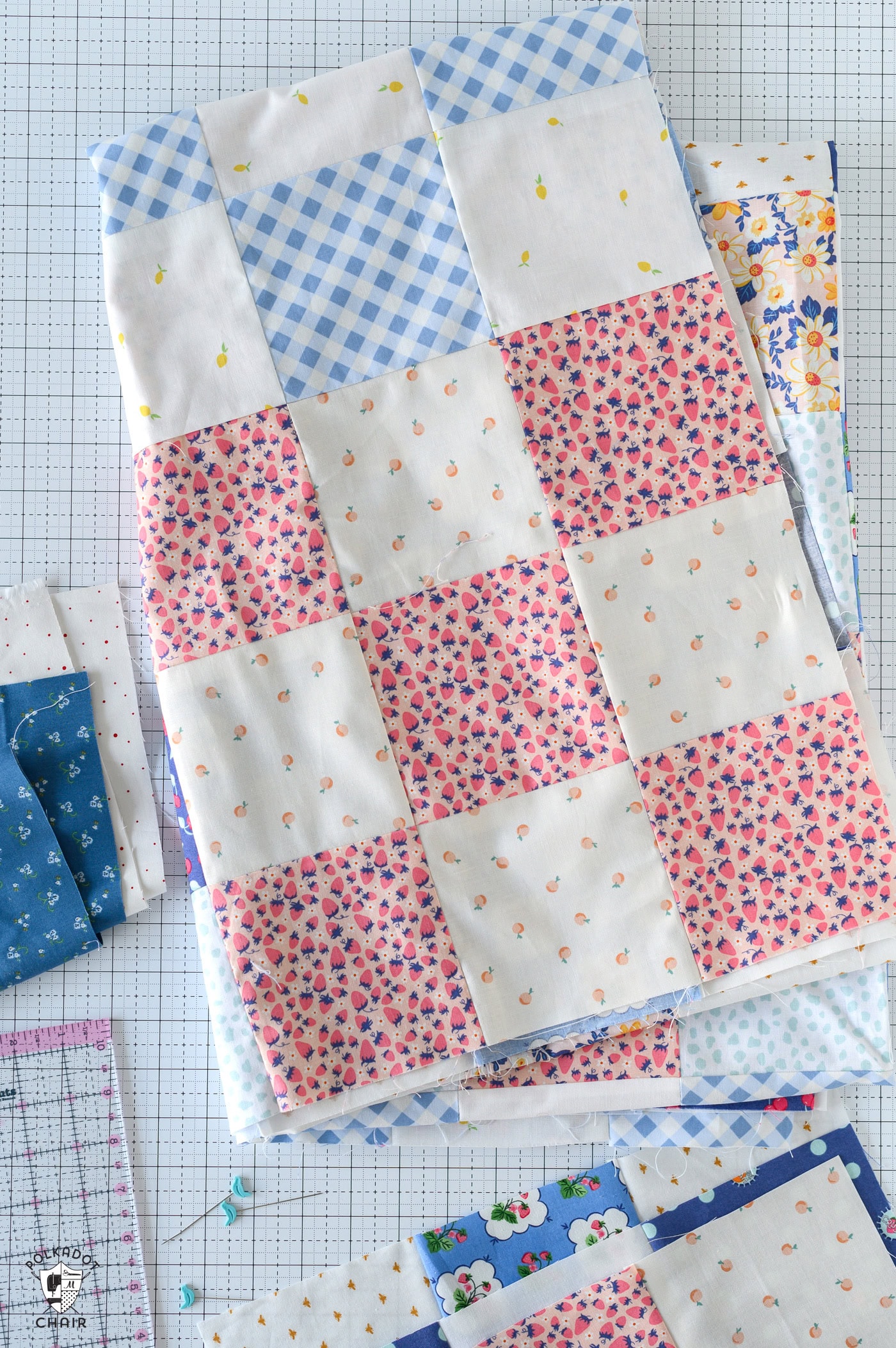 various pieces of fabric and quilting notions on white cutting mat