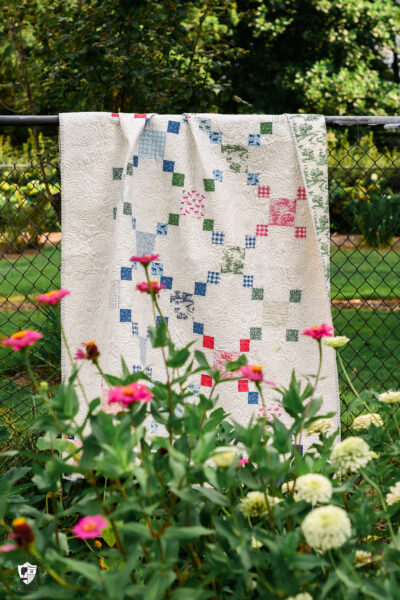 colorful chain quilt outdoors with flowers and greenery