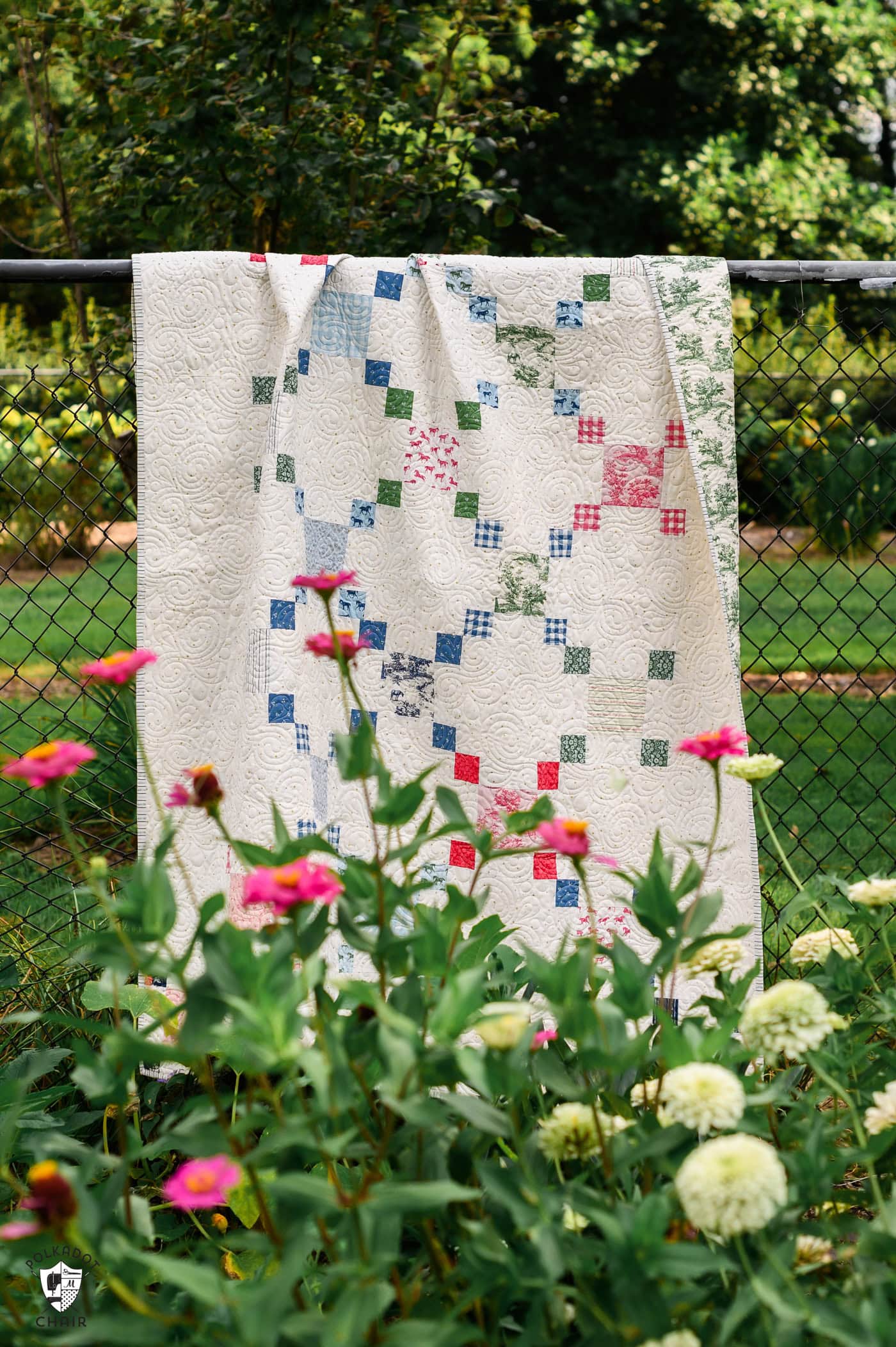 colorful chain quilt outdoors with flowers and greenery