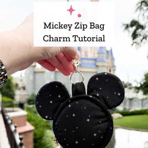 hand holding mickey head shaped bag charm outdoors