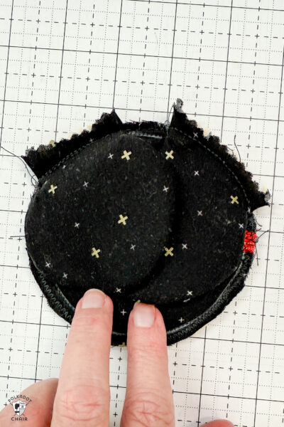 black fabric on cutting mat with red zipper showing construction steps of zip pouch