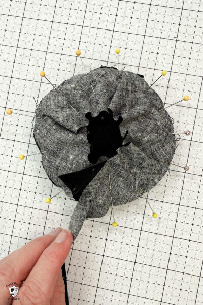 black fabric on cutting mat with red zipper showing construction steps of zip pouch