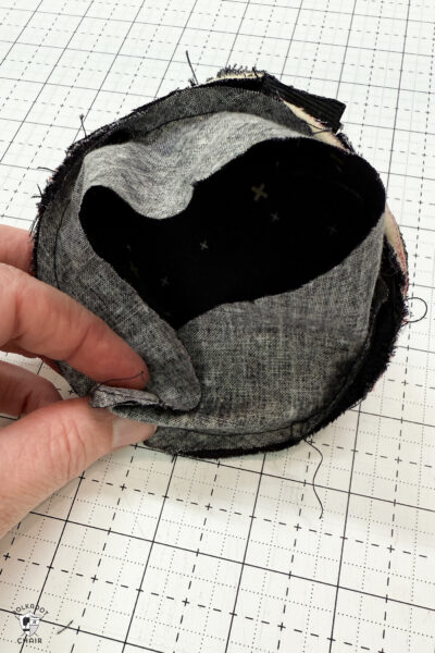 black fabric on cutting mat with red zipper showing construction steps of zip pouch