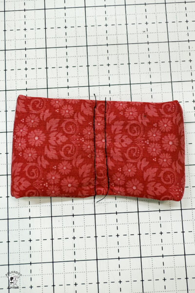 red fabric on cutting mat with showing construction steps of zip pouch