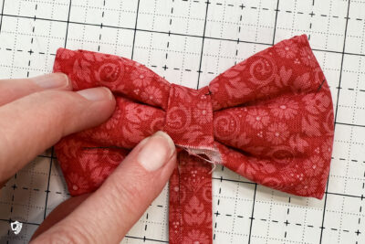 red fabric on cutting mat with showing construction steps of zip pouch