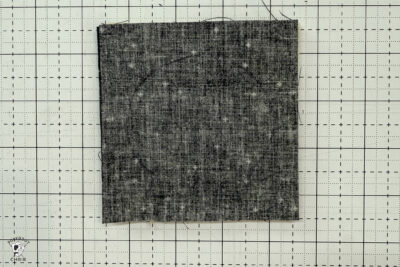 black fabric on cutting mat showing construction steps of zip pouch