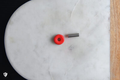 red clay circle on marble slab, with hole cut out in the middle and silver cookie cutter.