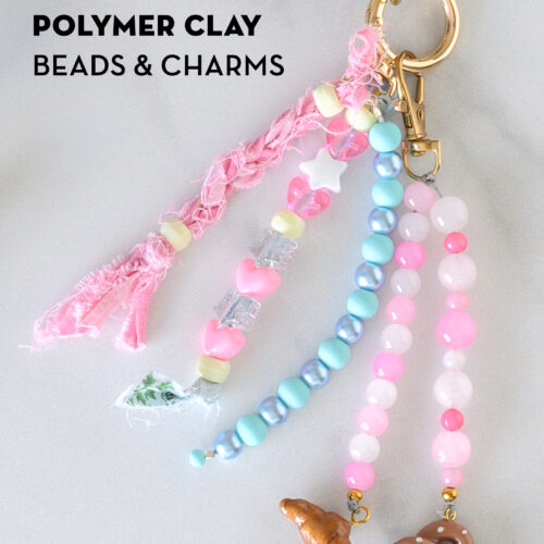 close up of pink and blue bag charms on white marble counter
