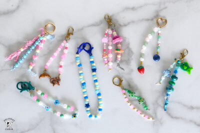 multiple colorful beaded bag charms with custom beads on white marble counter
