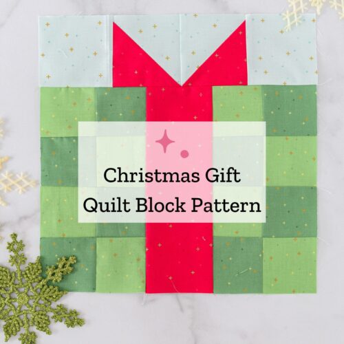 green and red present quilt block on white tabletop