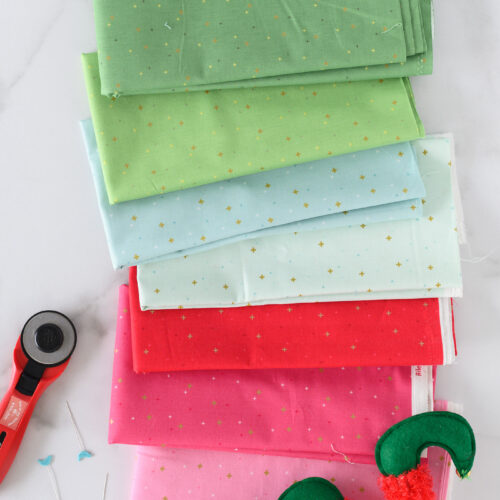 pink, red, blue and green fabrics folded on white marble countertop