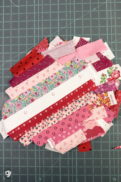 string quilt blocks on blue cutting mat