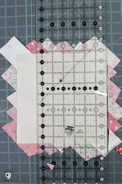 quilt ruler and paper and fabric on blue cutting mat