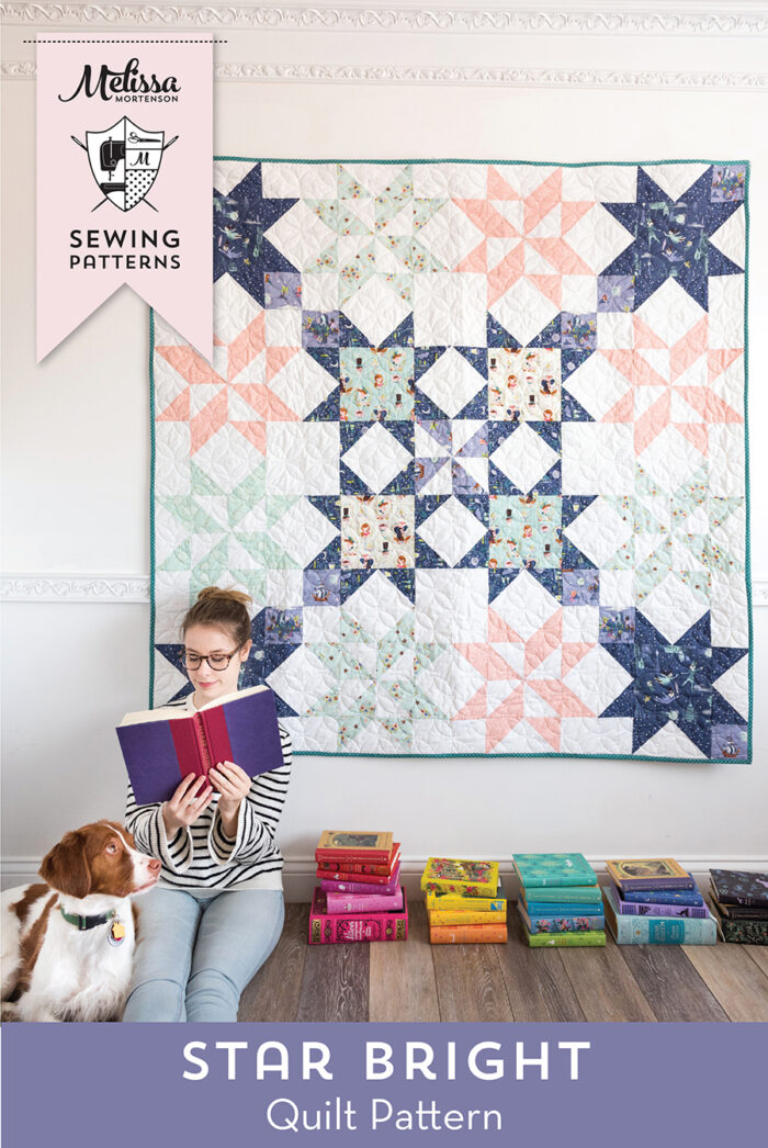 girl sitting in front of quilt with book in hand and dog
