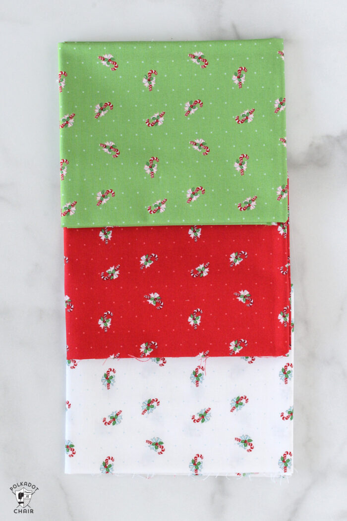 red and pink christmas fabric folded on white table