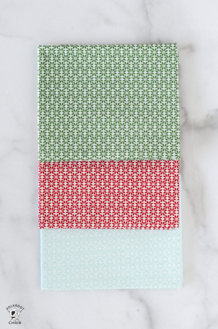 red and pink christmas fabric folded on white table