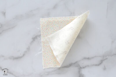 Polka dot fabric sample with floral and geometric patterns on white background.