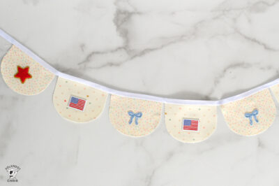 Handmade polka dot baby garland with stars and American flags for nursery decor.