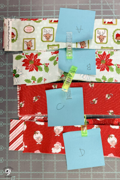 stacks of christmas fabric cut on cutting table