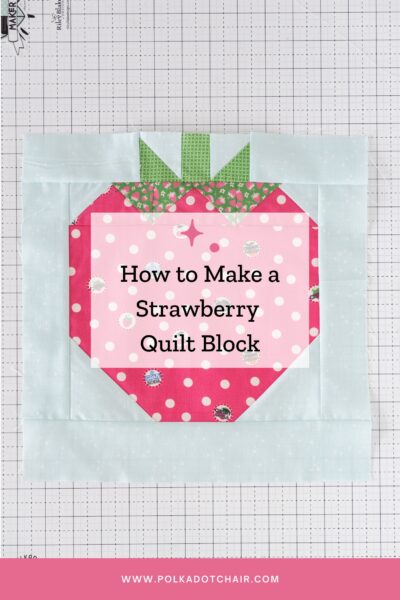 sewn strawberry quilt block on white cutting mat with text overlay
