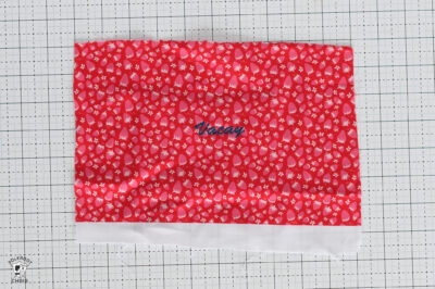 Red polka dot fabric with 'Vacay' text for craft or sewing projects.