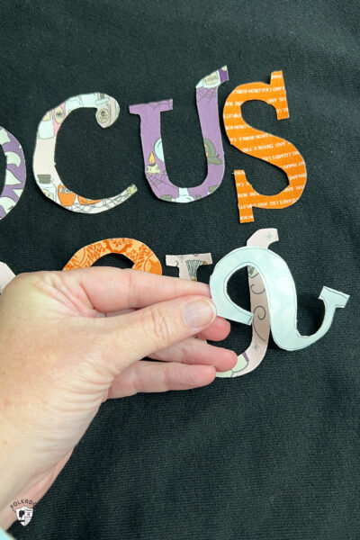 close up of Hocus Pocus Halloween letters on black sweatshirt